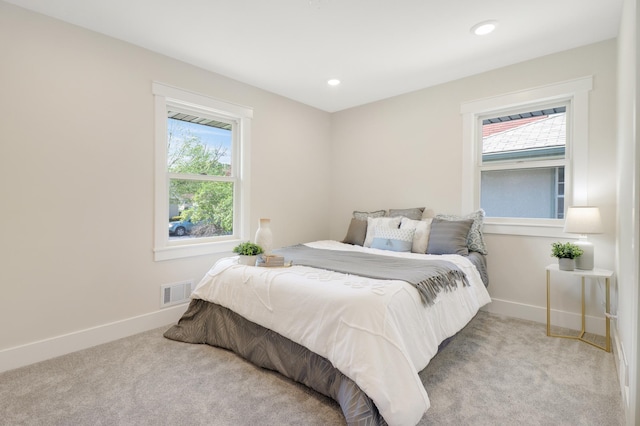 carpeted bedroom with multiple windows, baseboards, and recessed lighting