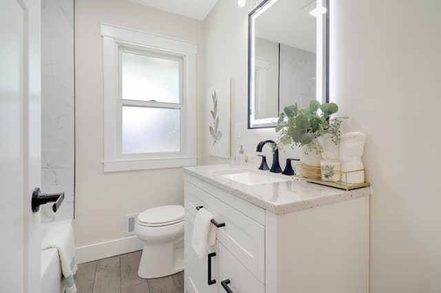 bathroom featuring vanity, toilet, baseboards, and wood finished floors