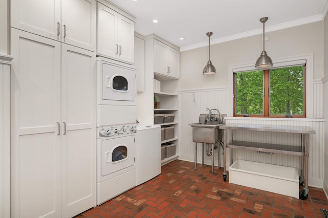 14575 268th Ave NW, Zimmerman, MN 55398 - washroom featuring stacked washer and clothes dryer, cabinet space, brick floors, wainscoting, and crown molding