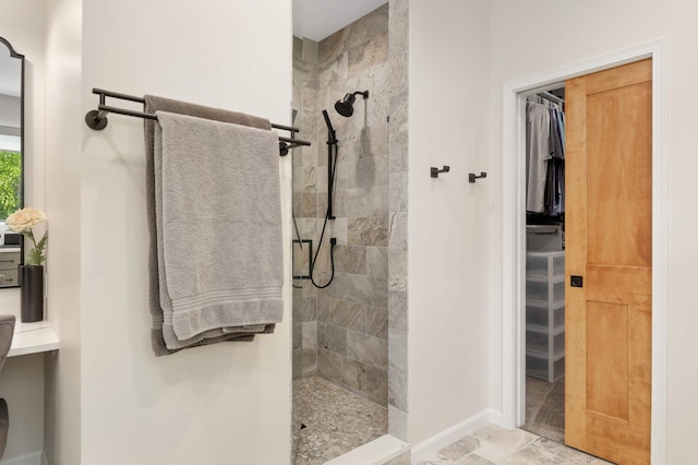 14575 268th Ave NW, Zimmerman, MN 55398 - bathroom featuring tiled shower, a spacious closet, and baseboards