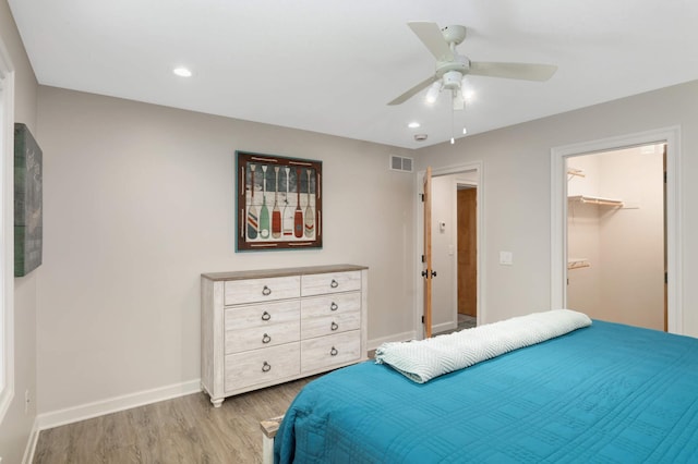 14575 268th Ave NW, Zimmerman, MN 55398 - bedroom featuring light wood-type flooring, baseboards, ceiling fan, recessed lighting, and a walk in closet