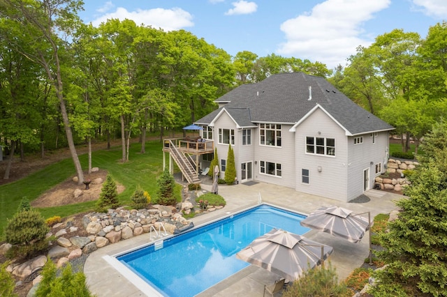 14575 268th Ave NW, Zimmerman, MN 55398 - back of property featuring a patio, a wooden deck, stairs, a shingled roof, and an outdoor pool