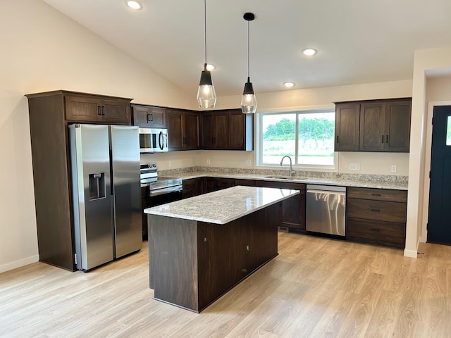 kitchen featuring stainless steel appliances, dark brown cabinetry, a kitchen island, a sink, and lofted ceiling