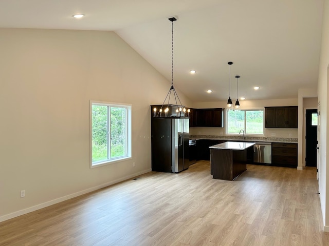 kitchen featuring stainless steel dishwasher, refrigerator with ice dispenser, a kitchen island, dark brown cabinets, and high vaulted ceiling