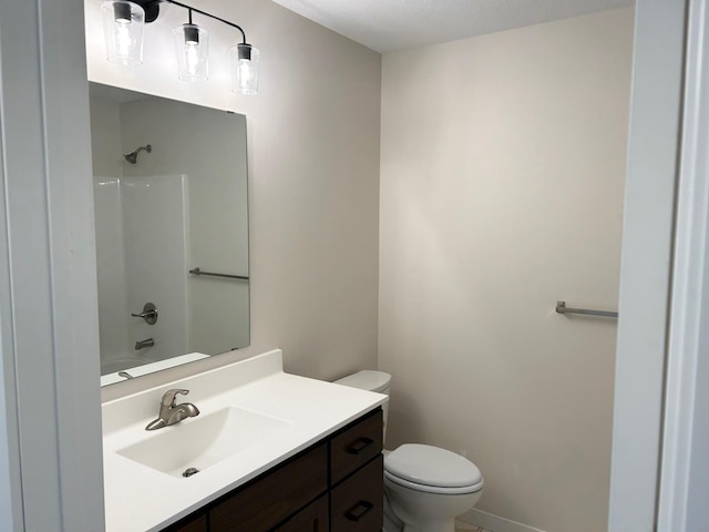 full bath featuring toilet, vanity, and baseboards