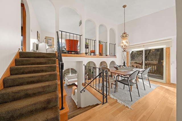 2622 159th Ave NE, Ham Lake, MN 55304 - dining room with stairs, a chandelier, wood finished floors, and a high ceiling