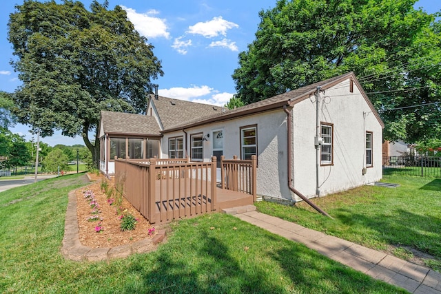 2216 57th St, Minneapolis, MN 55419 - back of house featuring a wooden deck, stucco siding, a sunroom, and roof with shingles