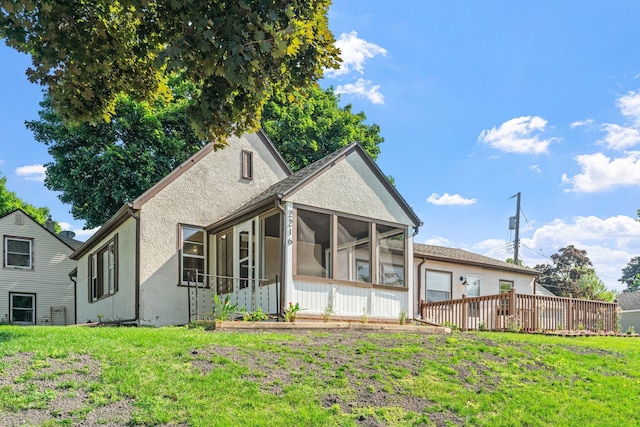 2216 57th St, Minneapolis, MN 55419 - back of property featuring a sunroom, stucco siding, and a lawn