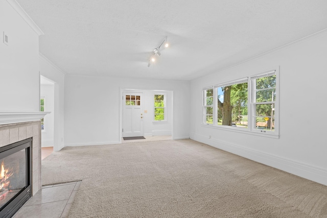 2216 57th St, Minneapolis, MN 55419 - unfurnished living room featuring a tile fireplace, light carpet, ornamental molding, and track lighting