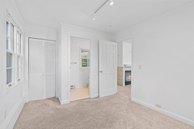 2216 57th St, Minneapolis, MN 55419 - unfurnished bedroom with carpet floors, a tiled fireplace, crown molding, a closet, and baseboard heating