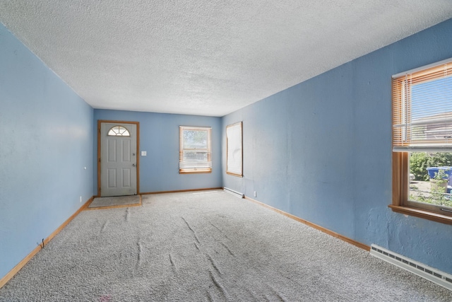 43 Hawthorne Ave W, Saint Paul, MN 55117 - carpeted empty room with baseboard heating, a textured ceiling, and baseboards