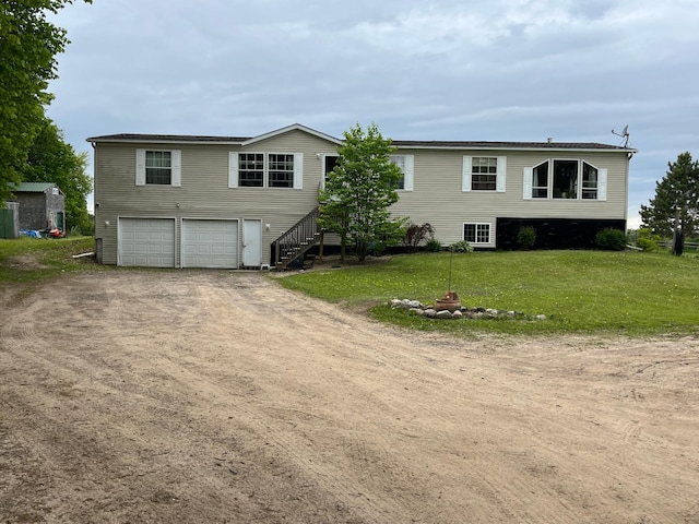 1141 Mahogany St, Mora, MN 55051 - view of front facade featuring driveway, an attached garage, a front lawn, and stairs