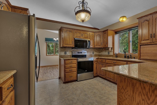17473 Fairway Cir, Cold Spring, MN 56320 - kitchen with stainless steel appliances, tasteful backsplash, vaulted ceiling, brown cabinets, and healthy amount of natural light