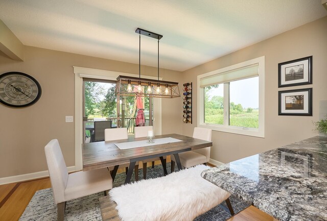dining area with wood finished floors, baseboards, and a chandelier