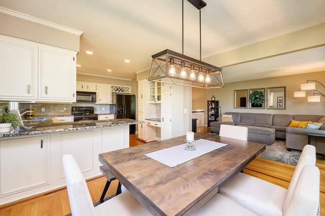 dining room featuring light wood-style flooring, recessed lighting, and ornamental molding