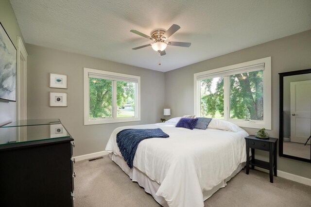 bedroom featuring baseboards, light colored carpet, and ceiling fan