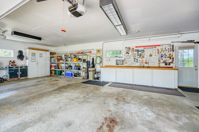 garage with a garage door opener and a workshop area