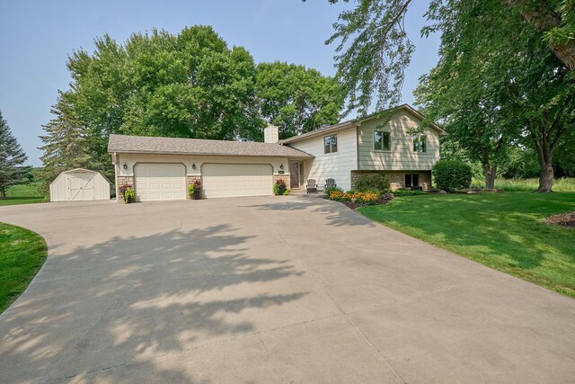 split level home with a storage shed, a front yard, a chimney, concrete driveway, and a garage