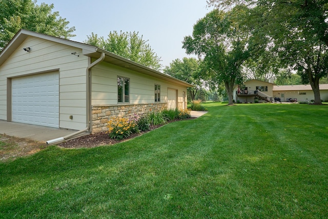 view of green lawn with a detached garage