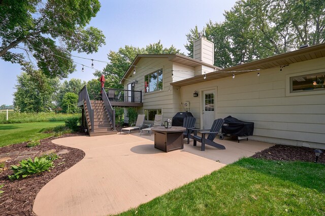 view of patio / terrace with stairway, a deck, a fire pit, and area for grilling