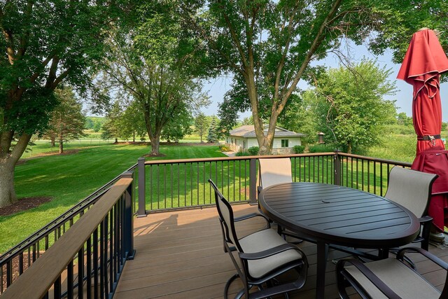 wooden terrace with outdoor dining area and a lawn