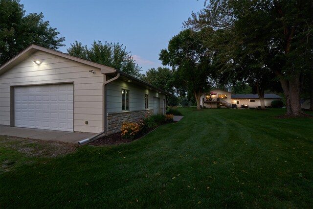 view of green lawn featuring a garage