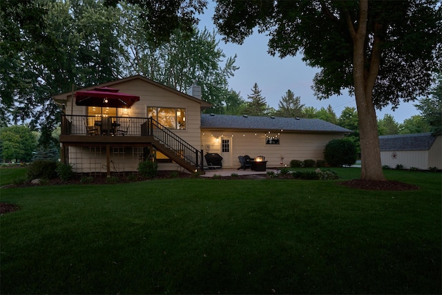back of property featuring stairs, a deck, a patio area, a lawn, and a chimney