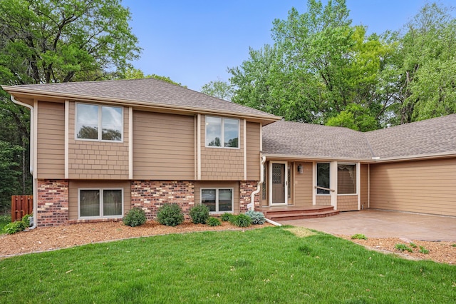 8681 144th Street Ct, Apple Valley, MN 55124 - split level home featuring a front lawn, brick siding, a patio area, concrete driveway, and roof with shingles