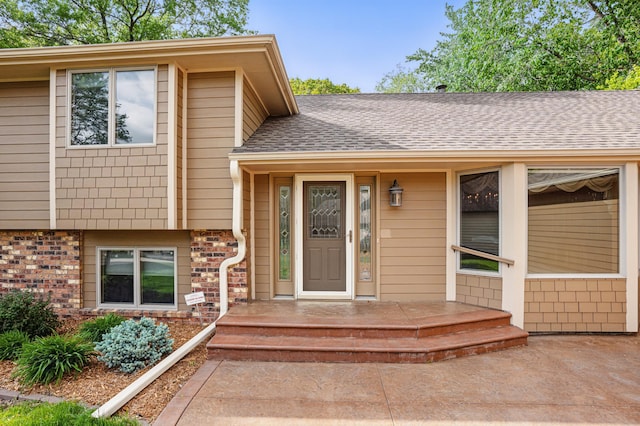 8681 144th Street Ct, Apple Valley, MN 55124 - doorway to property featuring a shingled roof and brick siding