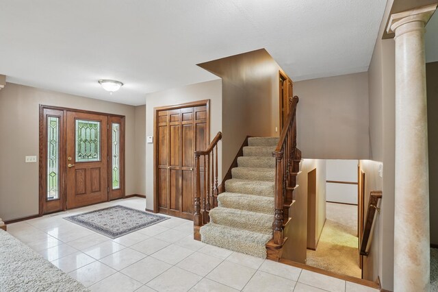 8681 144th Street Ct, Apple Valley, MN 55124 - foyer entrance featuring ornate columns, tile patterned floors, stairway, and baseboards