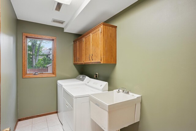 8681 144th Street Ct, Apple Valley, MN 55124 - clothes washing area with washer and dryer, cabinet space, baseboards, and light tile patterned flooring