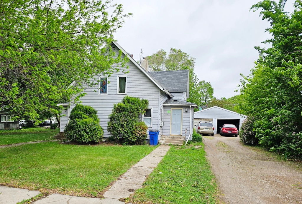 1008 11th Ave, Clarkfield, MN 56223 - view of front facade with an outdoor structure, a shingled roof, a garage, and a front yard