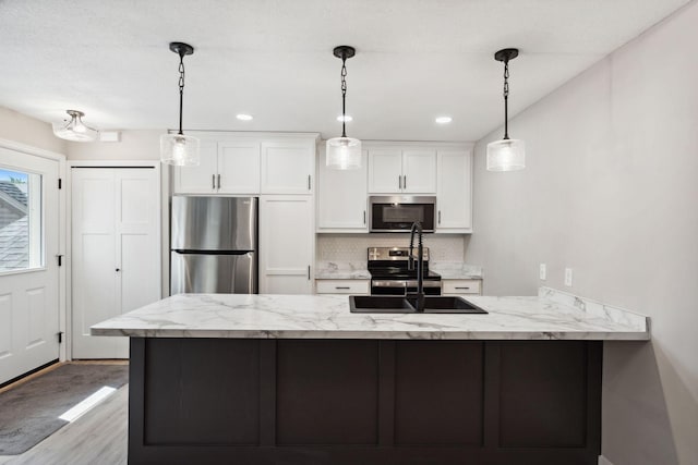 8754 Cottonwood Ln N, Maple Grove, MN 55369 - kitchen featuring appliances with stainless steel finishes, a sink, white cabinets, a peninsula, and wood finished floors