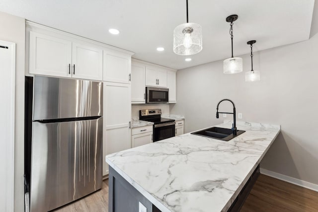 8754 Cottonwood Ln N, Maple Grove, MN 55369 - kitchen with appliances with stainless steel finishes, a sink, a peninsula, light wood-style floors, and white cabinetry