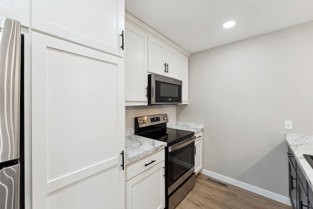 8754 Cottonwood Ln N, Maple Grove, MN 55369 - kitchen with stainless steel appliances, baseboards, light wood-style floors, white cabinetry, and recessed lighting