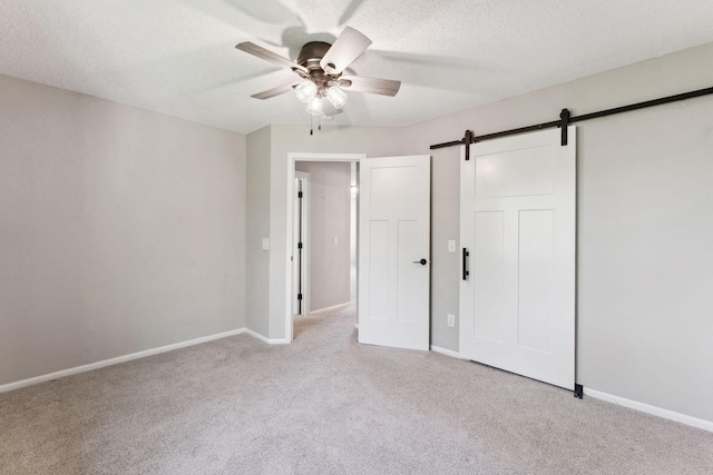 8754 Cottonwood Ln N, Maple Grove, MN 55369 - unfurnished bedroom featuring carpet flooring, a barn door, baseboards, and a textured ceiling