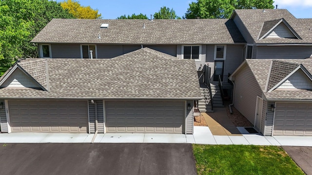 8754 Cottonwood Ln N, Maple Grove, MN 55369 - view of front of property featuring a shingled roof, driveway, an attached garage, and stairs