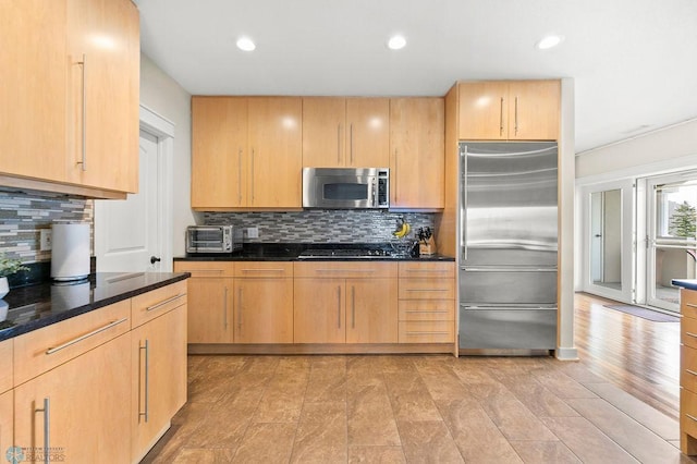 2501 30th Ave S Unit 201, Fargo, ND 58103 - kitchen featuring stainless steel appliances, backsplash, light brown cabinets, dark stone countertops, and recessed lighting
