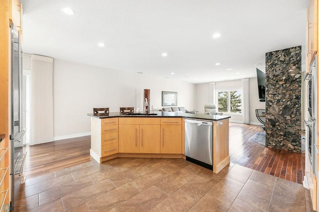2501 30th Ave S Unit 201, Fargo, ND 58103 - kitchen with stainless steel dishwasher, a sink, light brown cabinetry, dark countertops, and open floor plan