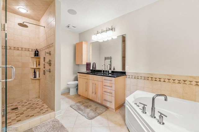 2501 30th Ave S Unit 201, Fargo, ND 58103 - full bathroom featuring a stall shower, vanity, a garden tub, tile patterned flooring, and toilet