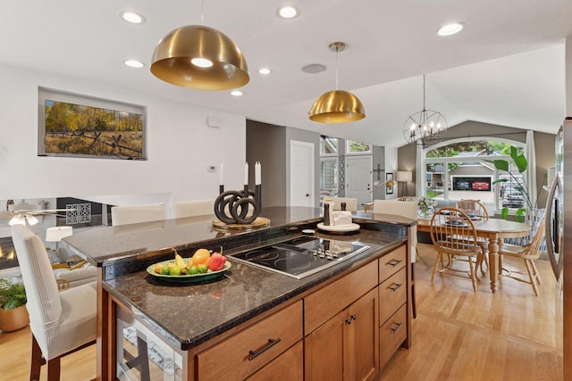 4084 Wild Goose Ln, White Bear Twp, MN 55110 - kitchen featuring black electric cooktop, a kitchen island, light wood-style floors, brown cabinets, and pendant lighting
