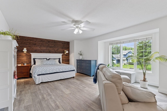 4084 Wild Goose Ln, White Bear Twp, MN 55110 - bedroom with wood walls, light wood-style flooring, and a ceiling fan