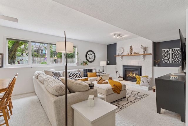 4084 Wild Goose Ln, White Bear Twp, MN 55110 - living room with light colored carpet, a brick fireplace, a textured ceiling, and track lighting