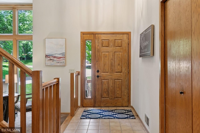 12762 Foliage Ave, Apple Valley, MN 55124 - entryway with light tile patterned floors, healthy amount of natural light, baseboards, stairway, and a towering ceiling