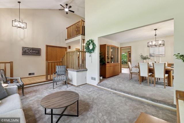 12762 Foliage Ave, Apple Valley, MN 55124 - carpeted living room with a chandelier, stairs, a ceiling fan, high vaulted ceiling, and baseboards