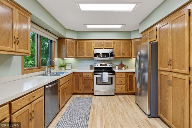 12762 Foliage Ave, Apple Valley, MN 55124 - kitchen featuring appliances with stainless steel finishes, a sink, light countertops, and light wood-style floors