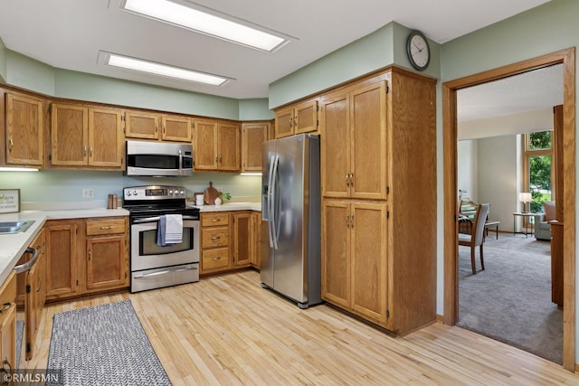 12762 Foliage Ave, Apple Valley, MN 55124 - kitchen with appliances with stainless steel finishes, light countertops, brown cabinets, and light wood-style floors