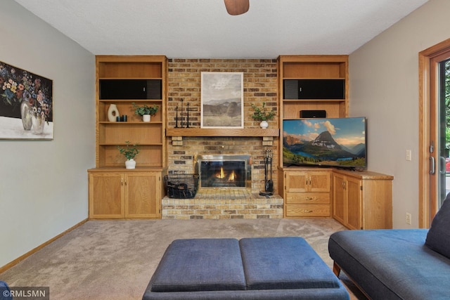 12762 Foliage Ave, Apple Valley, MN 55124 - living area with carpet flooring, a brick fireplace, baseboards, built in shelves, and a ceiling fan