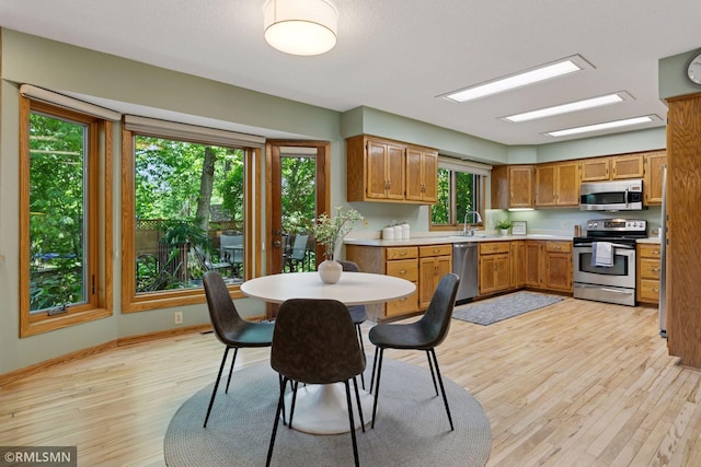 12762 Foliage Ave, Apple Valley, MN 55124 - kitchen with stainless steel appliances, light wood finished floors, light countertops, brown cabinets, and a sink