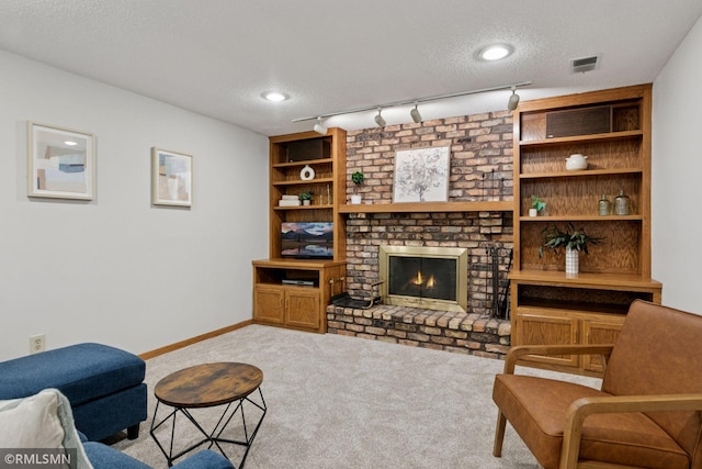 12762 Foliage Ave, Apple Valley, MN 55124 - living room featuring carpet floors, a textured ceiling, a brick fireplace, baseboards, and track lighting